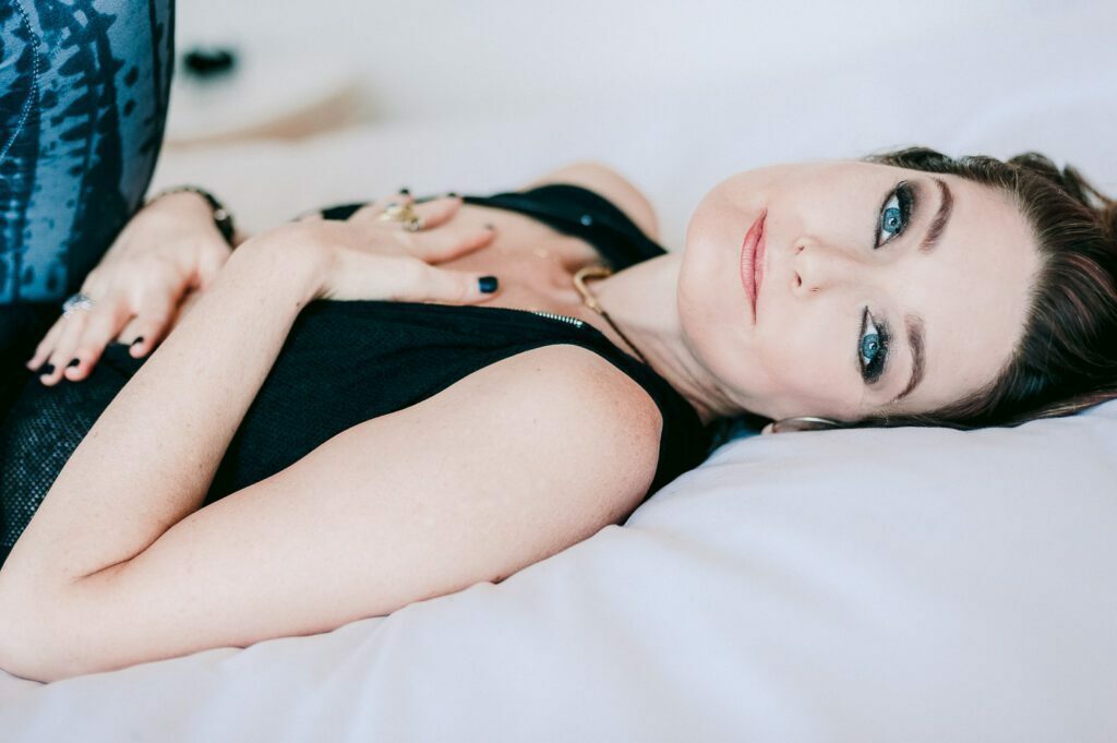 Lying on the bed with her hands over her heart