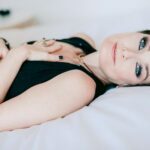 Lying on the bed with her hands over her heart