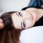 Sagarra lying on the bed looking at the camera