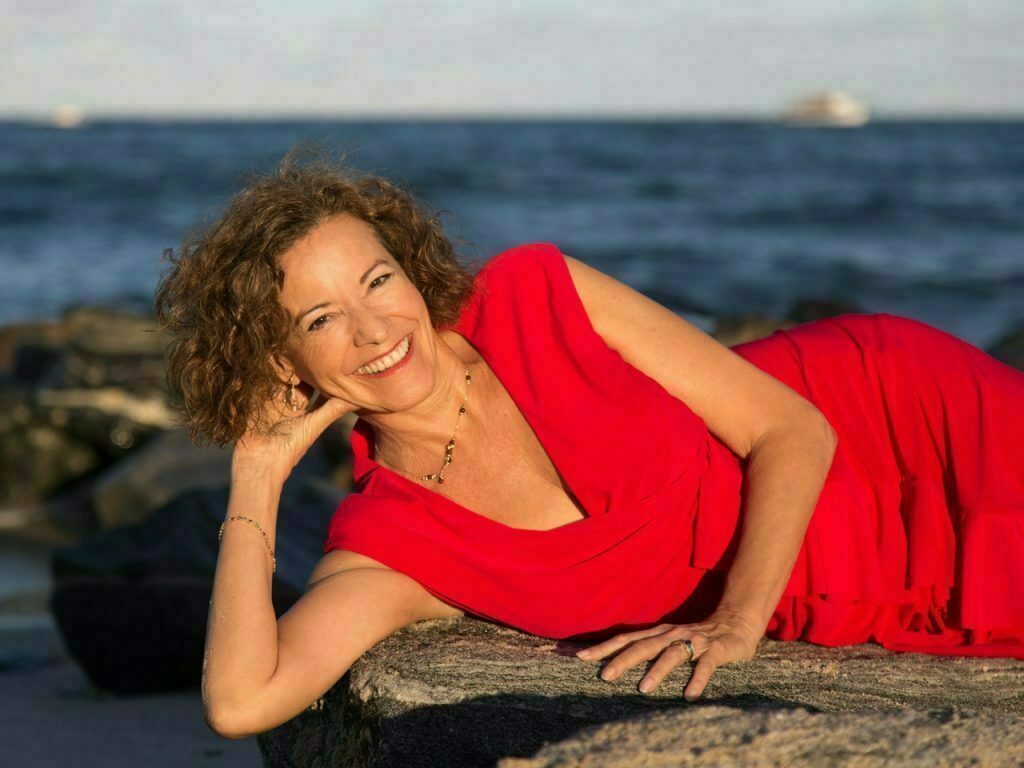 Lourdes layng down in the same red dress