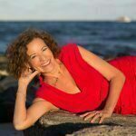 Lourdes layng down in the same red dress