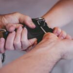 Close-up of someones hands being tied together.