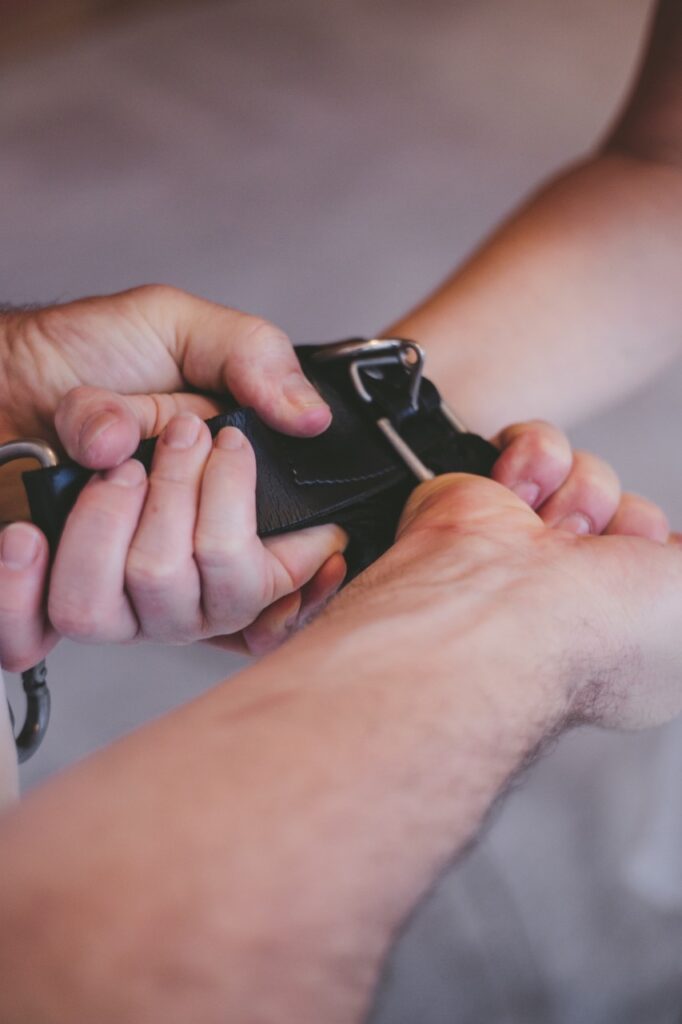 Close-up of someones hands being tied together.