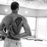 Christian without a shirt from the back.