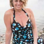 Dawn in a spotted dress in front of a body of water