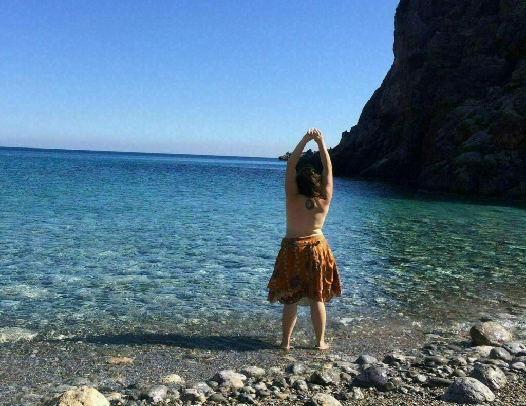 On a beach with her feet in the water