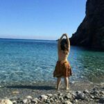 On a beach with her feet in the water