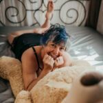 Tracy Lee lying on the bed with a teddy