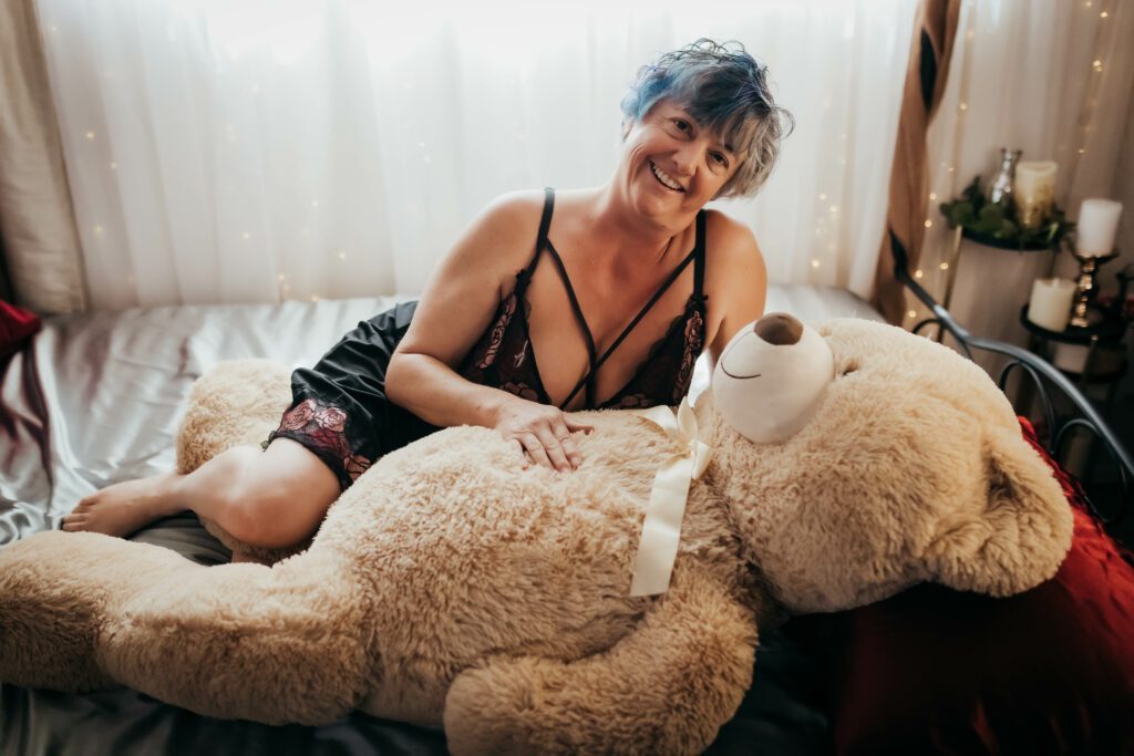 Tracy Lee cuddling with a teddy on the bed