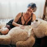 Tracy Lee cuddling with a teddy on the bed