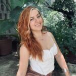 Sureya sitting in a white shirt and smiling