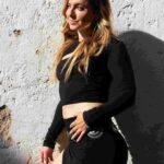 Sureya Leonara dressed in back against a white wall
