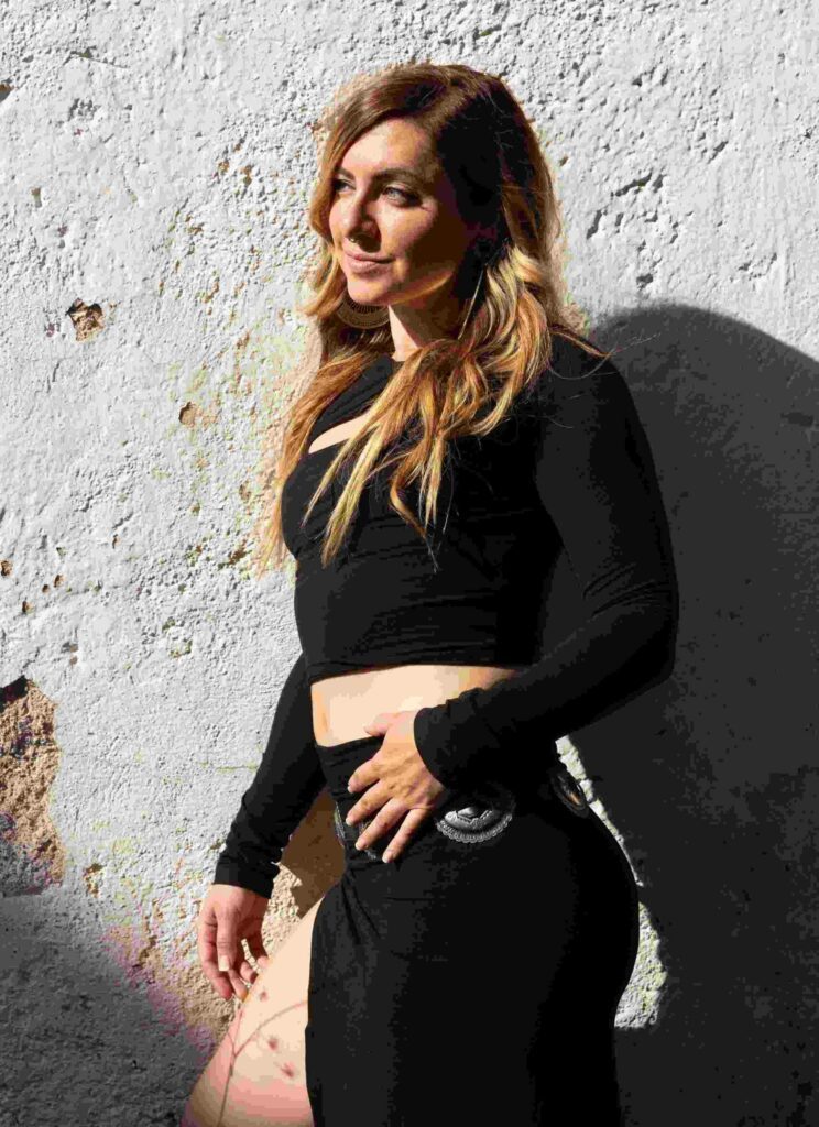 Sureya Leonara dressed in back against a white wall