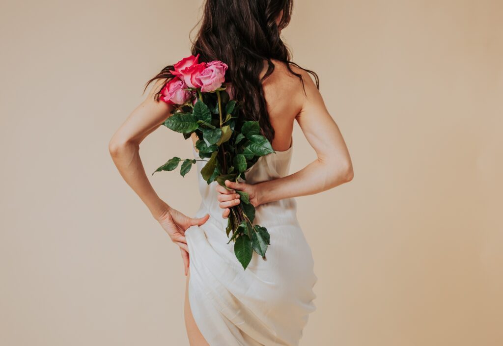 Eva Pearl holding flowers behind her back