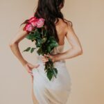 Eva Pearl holding flowers behind her back