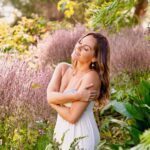 Lia Light in lush nature embracing herself.
