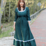Lora standing in a green dress