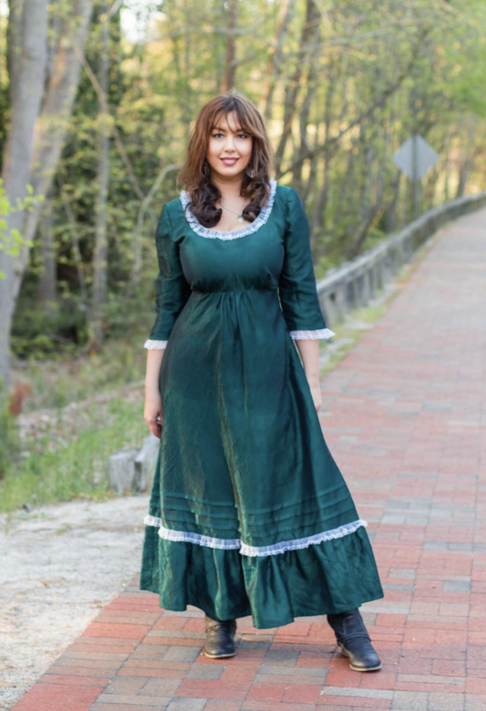 Lora standing in a green dress