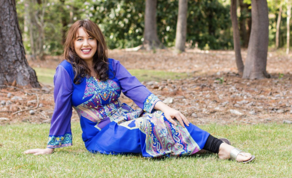 Lora on the grass in a bue dress