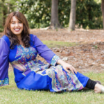 Lora on the grass in a bue dress