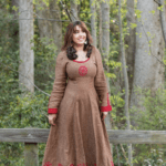 Lora standing in a brown dress