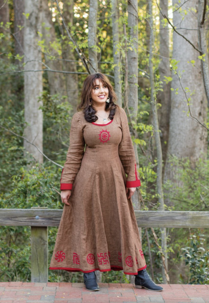 Lora standing in a brown dress