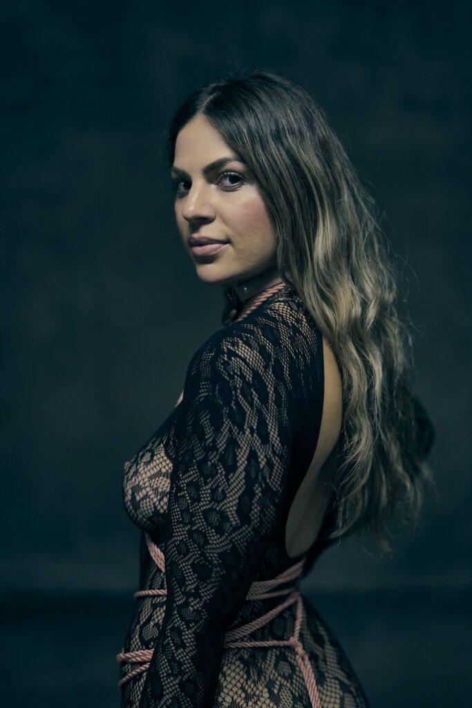 Lady M. Svarga dressed in black looking over her shoulder