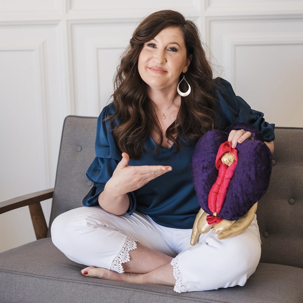 Raven on the couch pointing at a soft vagina-toy.