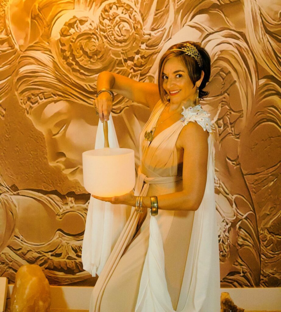 Angela playing on a white crystal singing bowl.
