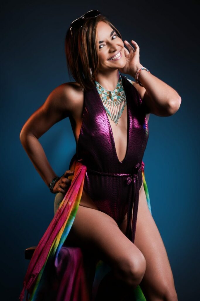 Angela in a purple shiny dress and rainbow-colored scarf.