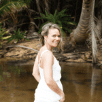 Rose walking thorugh water holding up her white dress