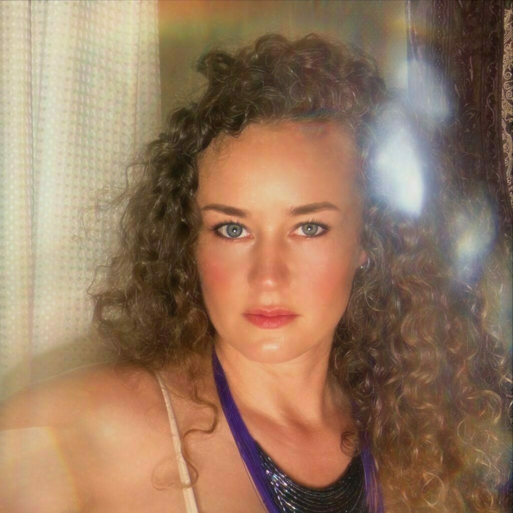 Rae Preston looking deeply int he camera with a blue top on