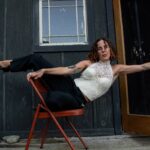 Funky shot of Calypso balancing on a chair leaning agaist a door.