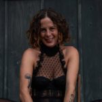 Giggling Calypso in a dark outfit.