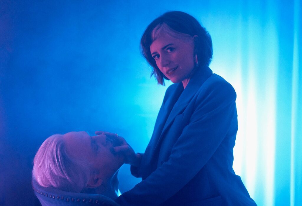 Mistress Em covered in blue with a client