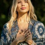 Sun shining on Dahlia's face. She has her hands crossed in front of her chest.