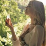 Dahlia holding a crystal in one hand and having her eyes closed.