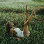 Amy in a white dress lying in the grass.