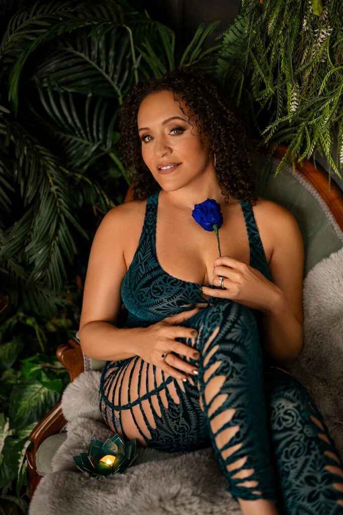 Christy Rose dressed in black with a blue flower