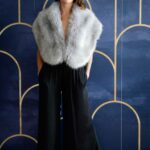 Lila wearing a fluffy coat and black trousers.