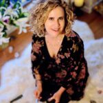 Clair kneeling on the floor in a black dress
