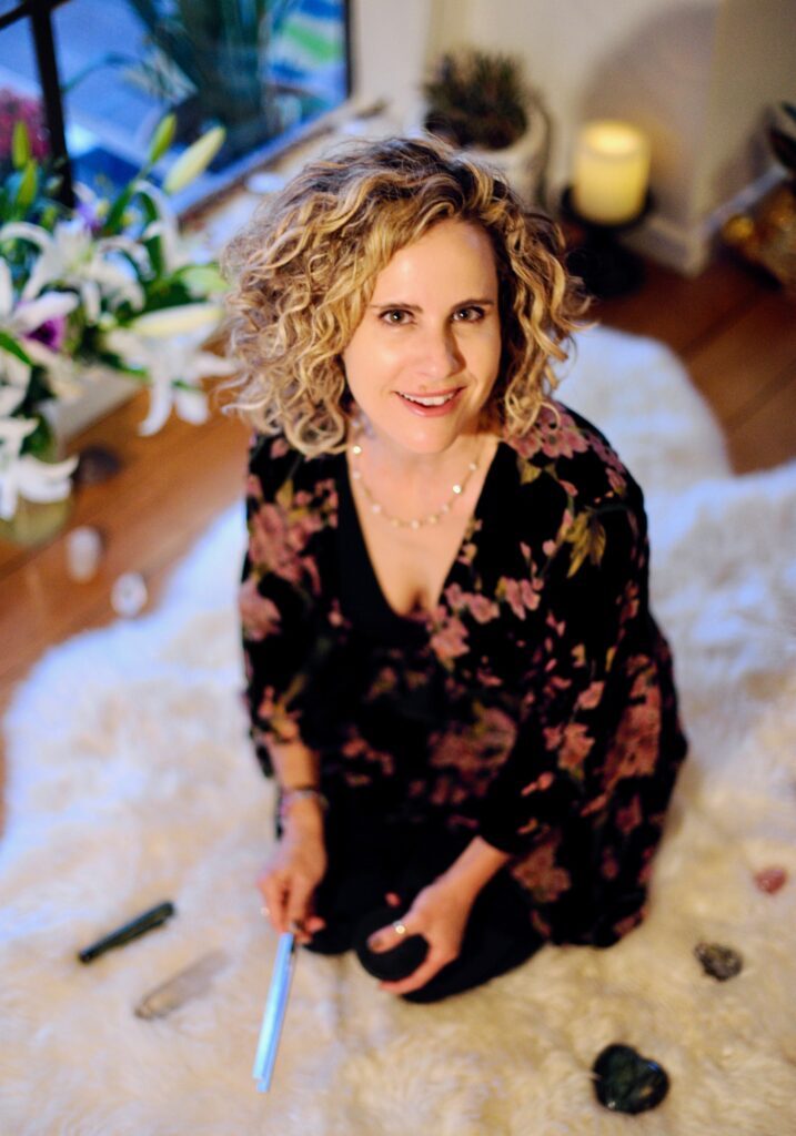 Clair kneeling on the floor in a black dress