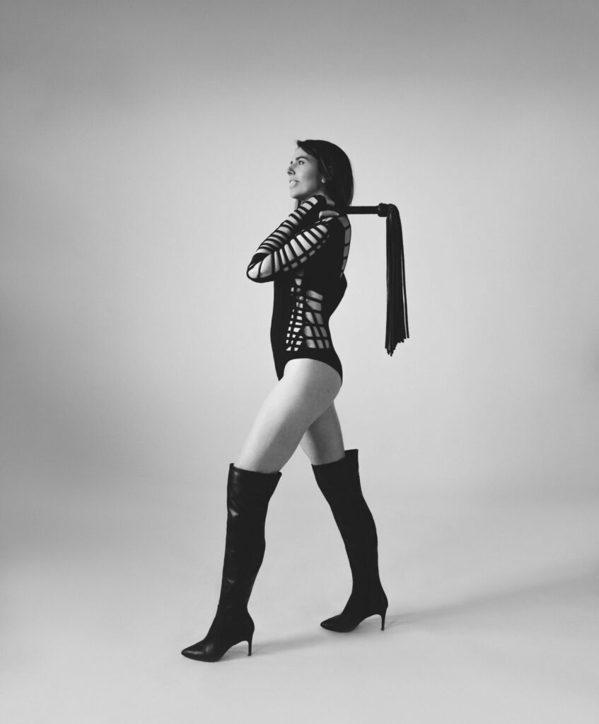 Janelle Marie holding a flogger
