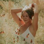 Anastasia fixing her hair in tall grass