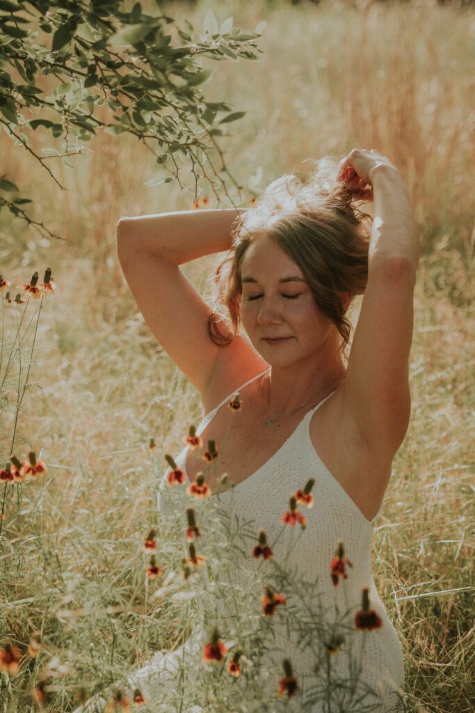 Anastasia fixing her hair in tall grass
