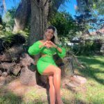Ellie f dressed in green sitting in front of a tree