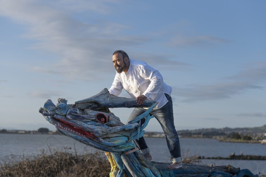 Tevita Standing on a wooden sculpture
