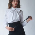 Mistress Seren in lingerie holding a crop