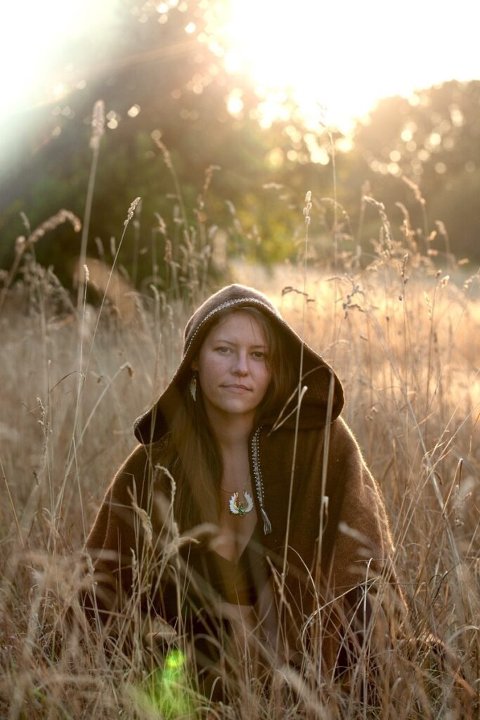 Priestess Hannah hooded in tall grass