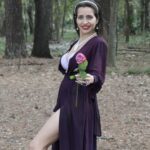 Nohami in the woods holding a rose.